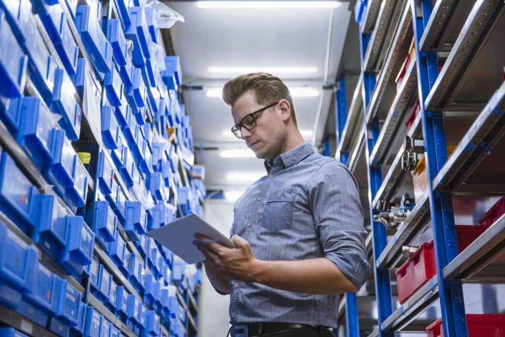 Man in glasses on tablet near asset inventory.