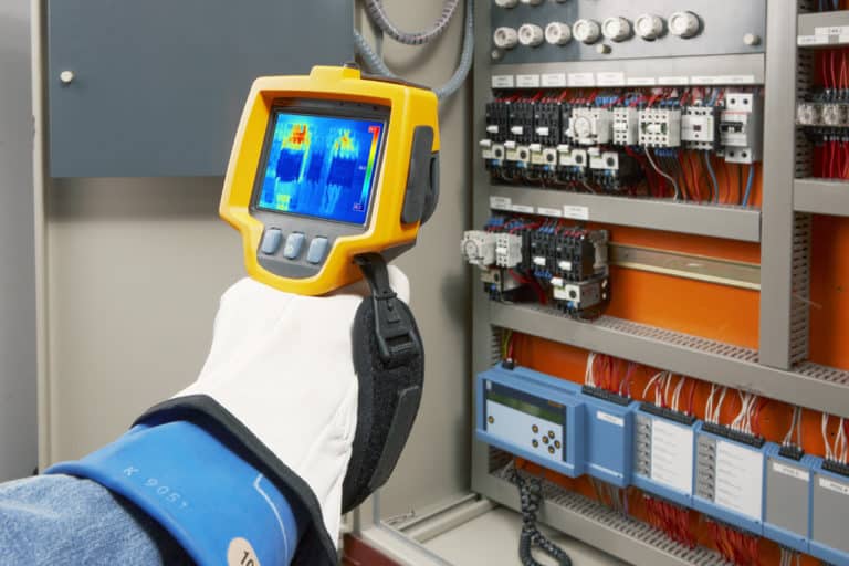Hand using scanner to complete thermographic testing.